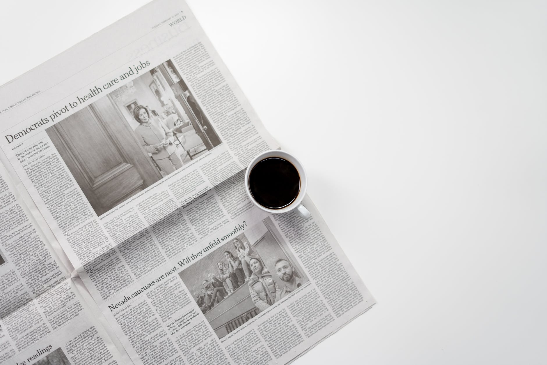 white ceramic mug on top of a newspaper